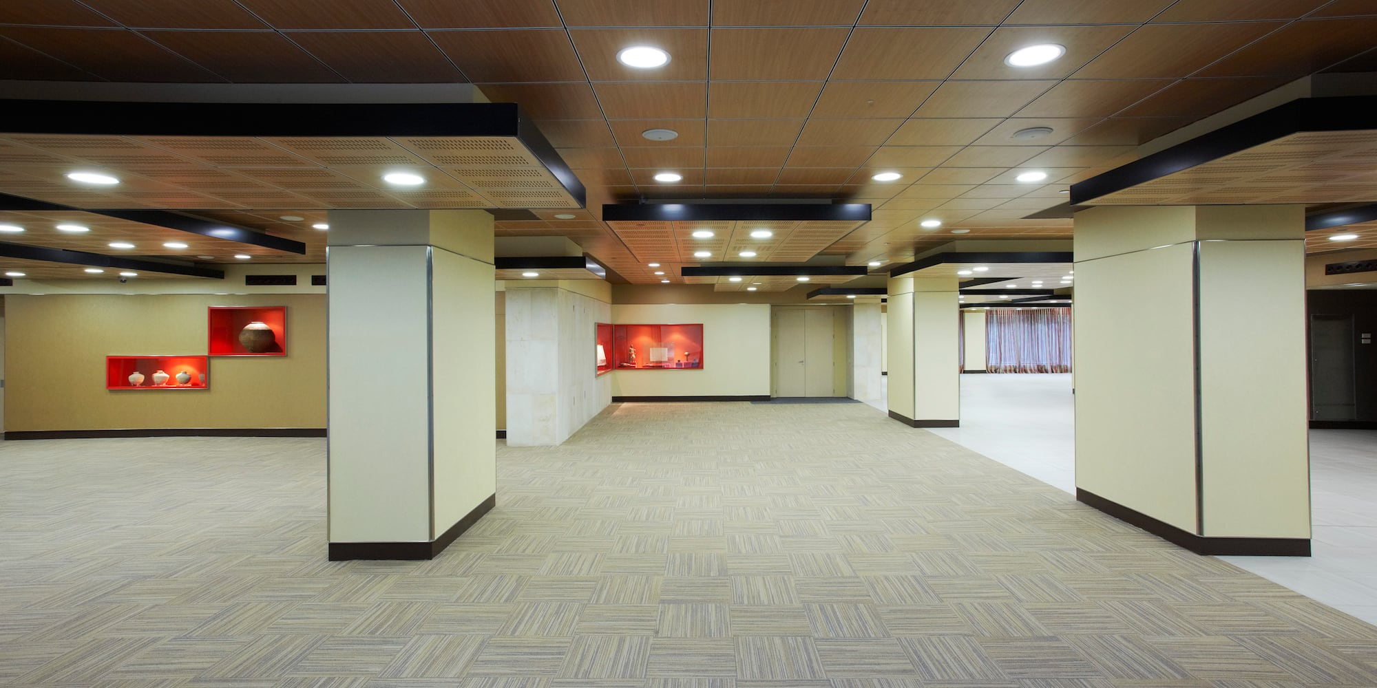 a large room with a tile floor and a red wall