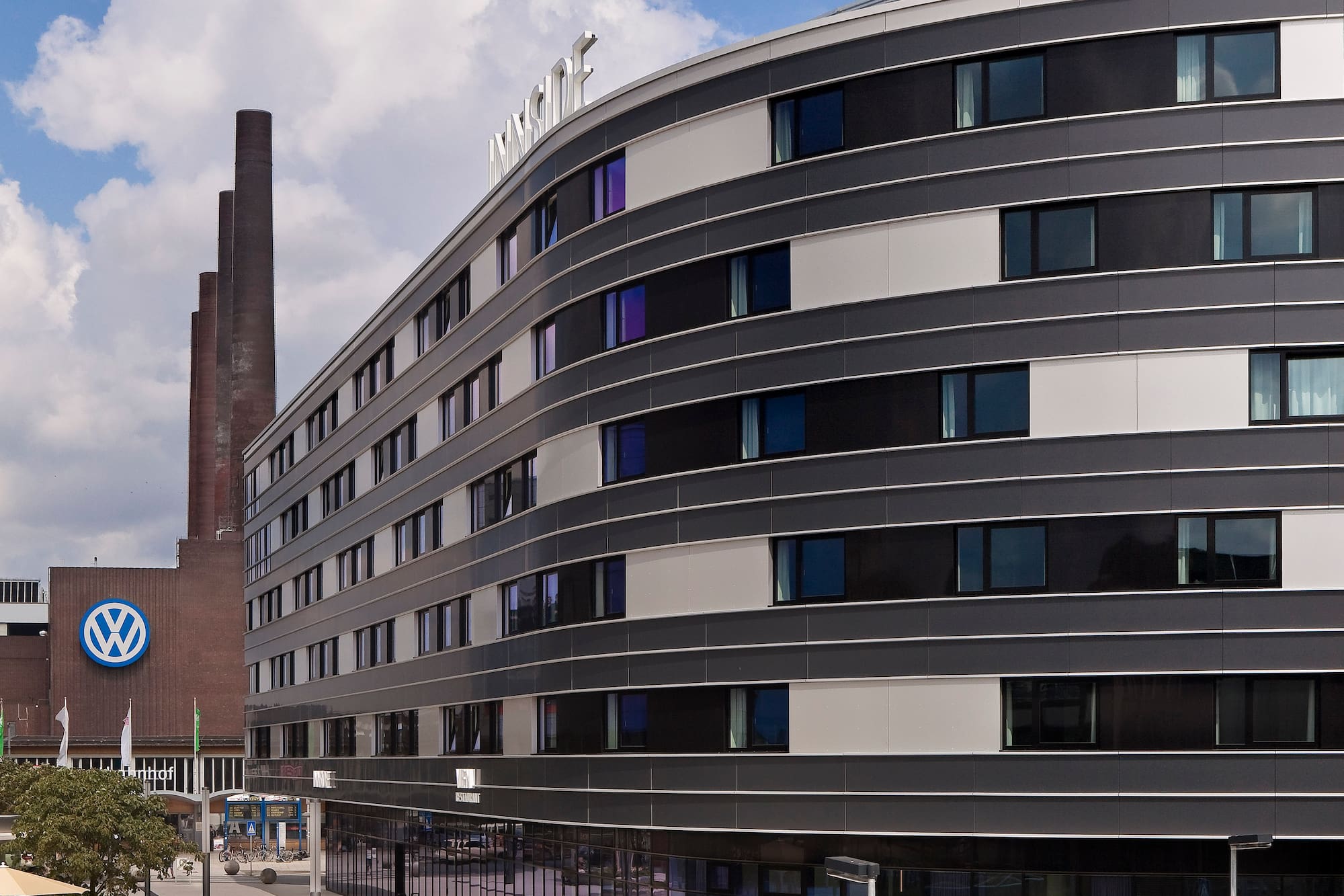 Curved INNSiDE hotel building, Volkswagen factory chimneys, Wolfsburg.