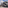 Modern curved INNSIDE hotel, VW factory with chimneys, outdoor dining area.