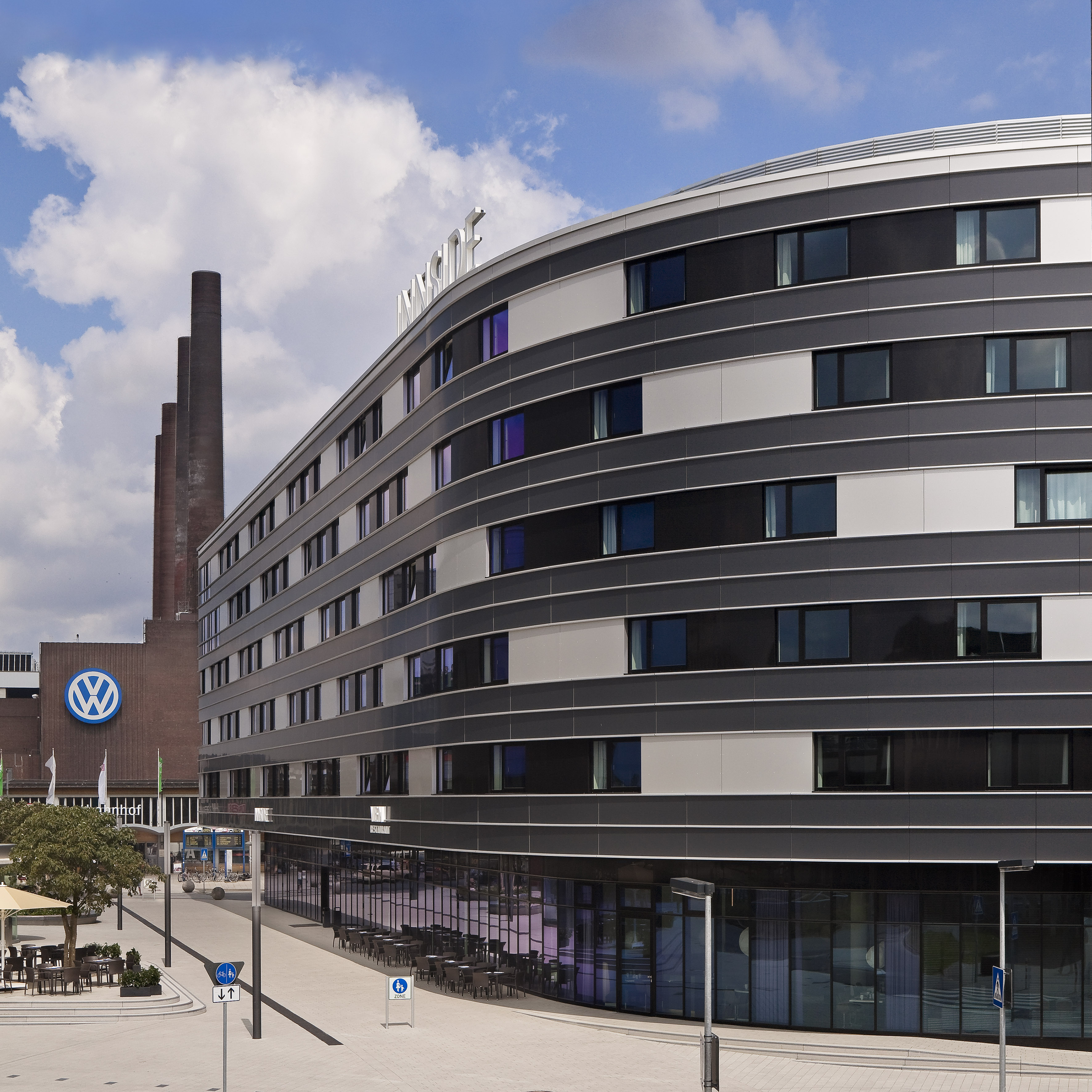 Curved INNSiDE hotel building, Volkswagen factory chimneys, Wolfsburg.