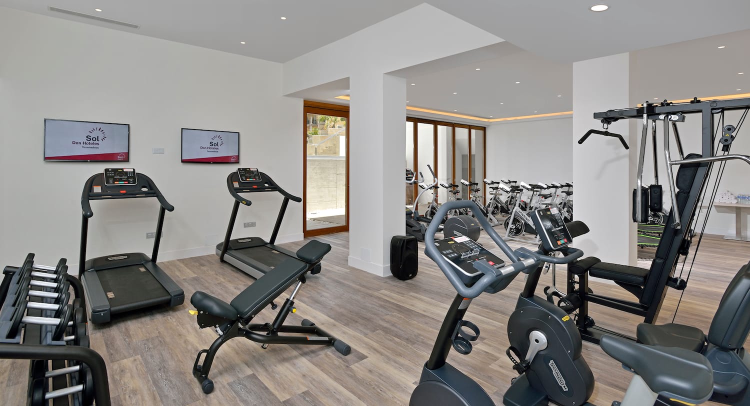a room with exercise equipment and a television