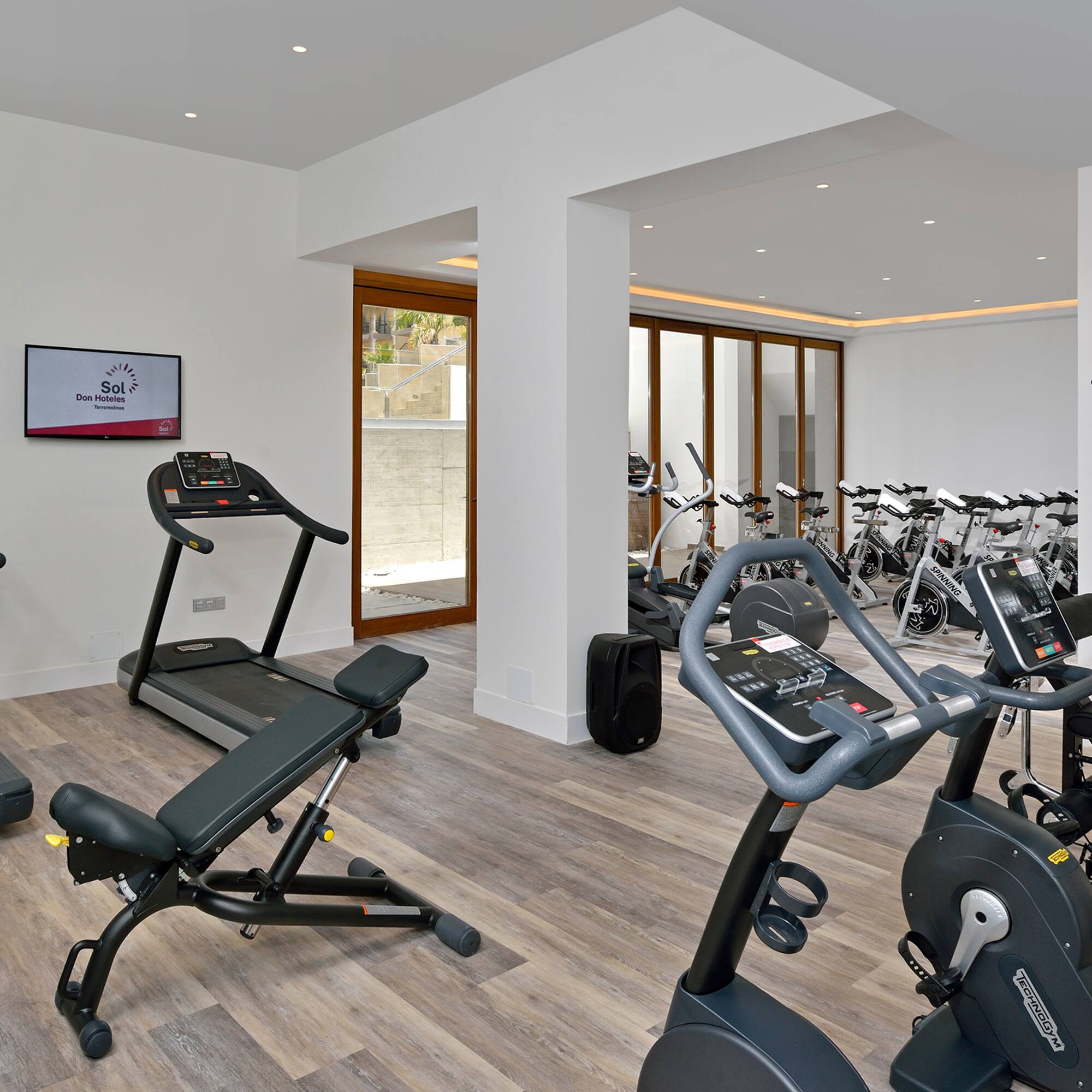 a room with exercise equipment and a television