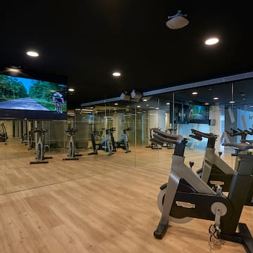 a room with exercise bikes and a large screen