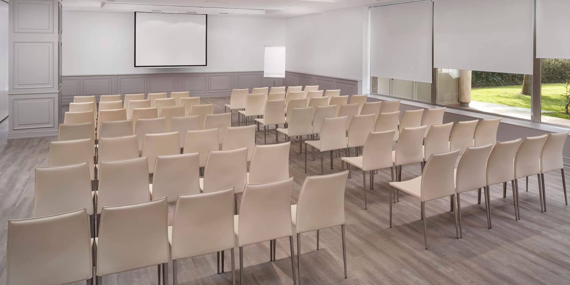 a room with white chairs and a projector screen