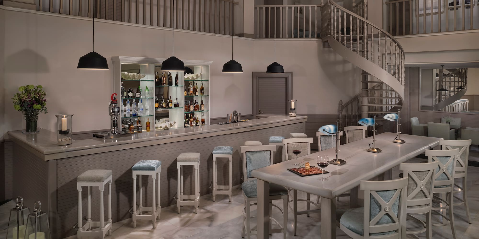 a room with a spiral staircase and a bar