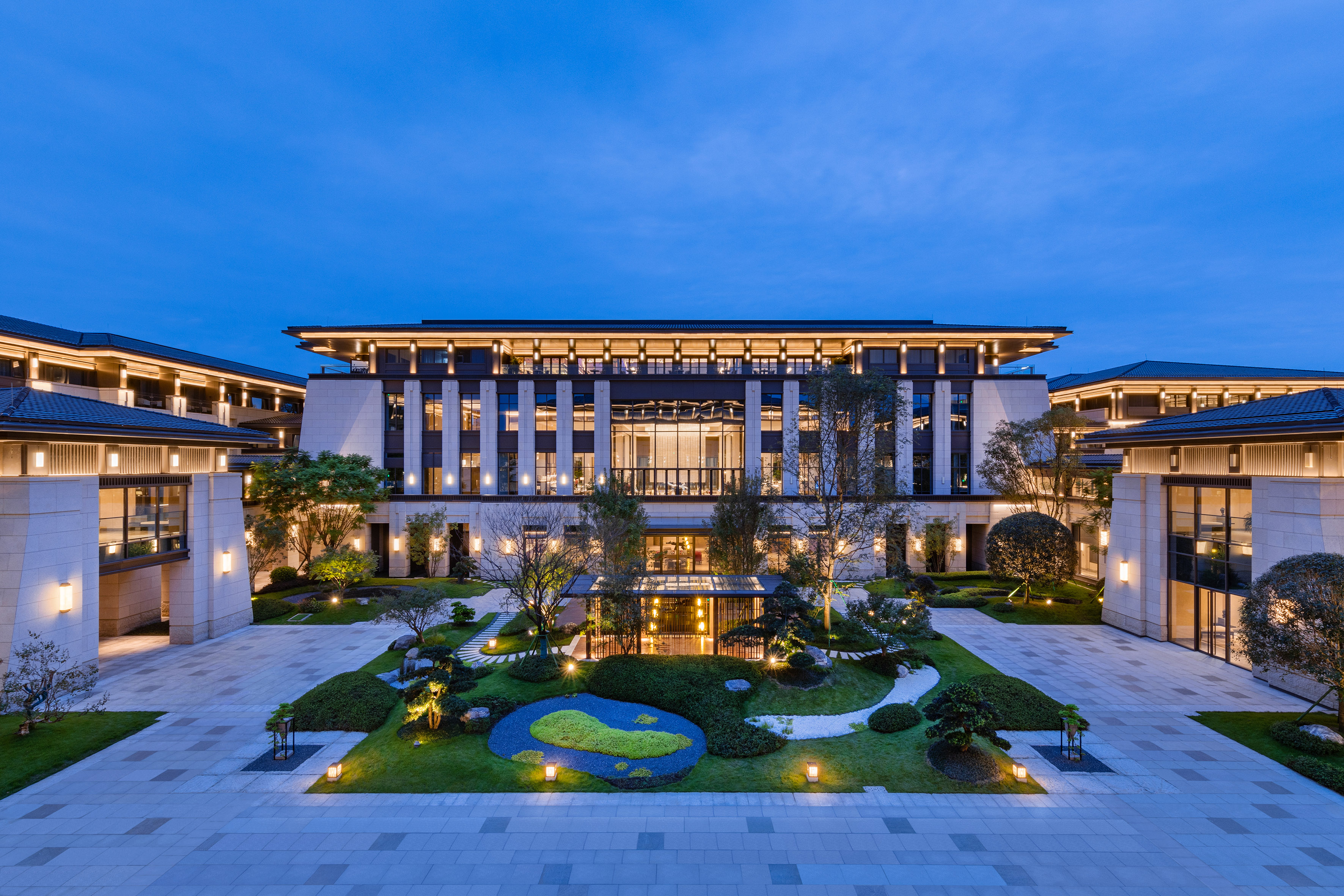 Luxury building with modern Asian architecture and illuminated courtyard garden.