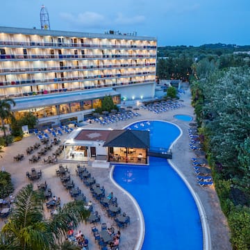 a pool and a building with chairs and trees