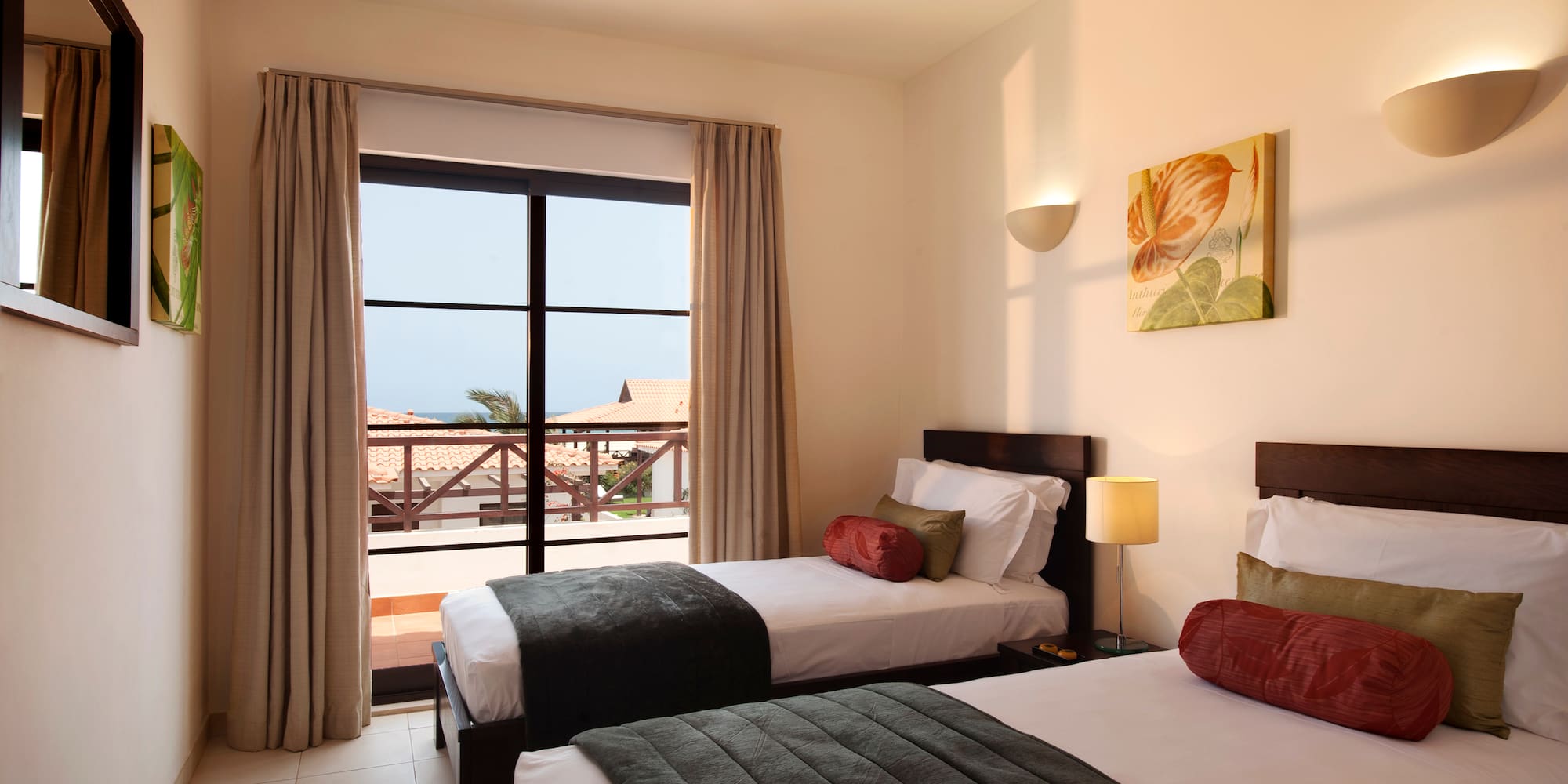 two beds in a room with a balcony