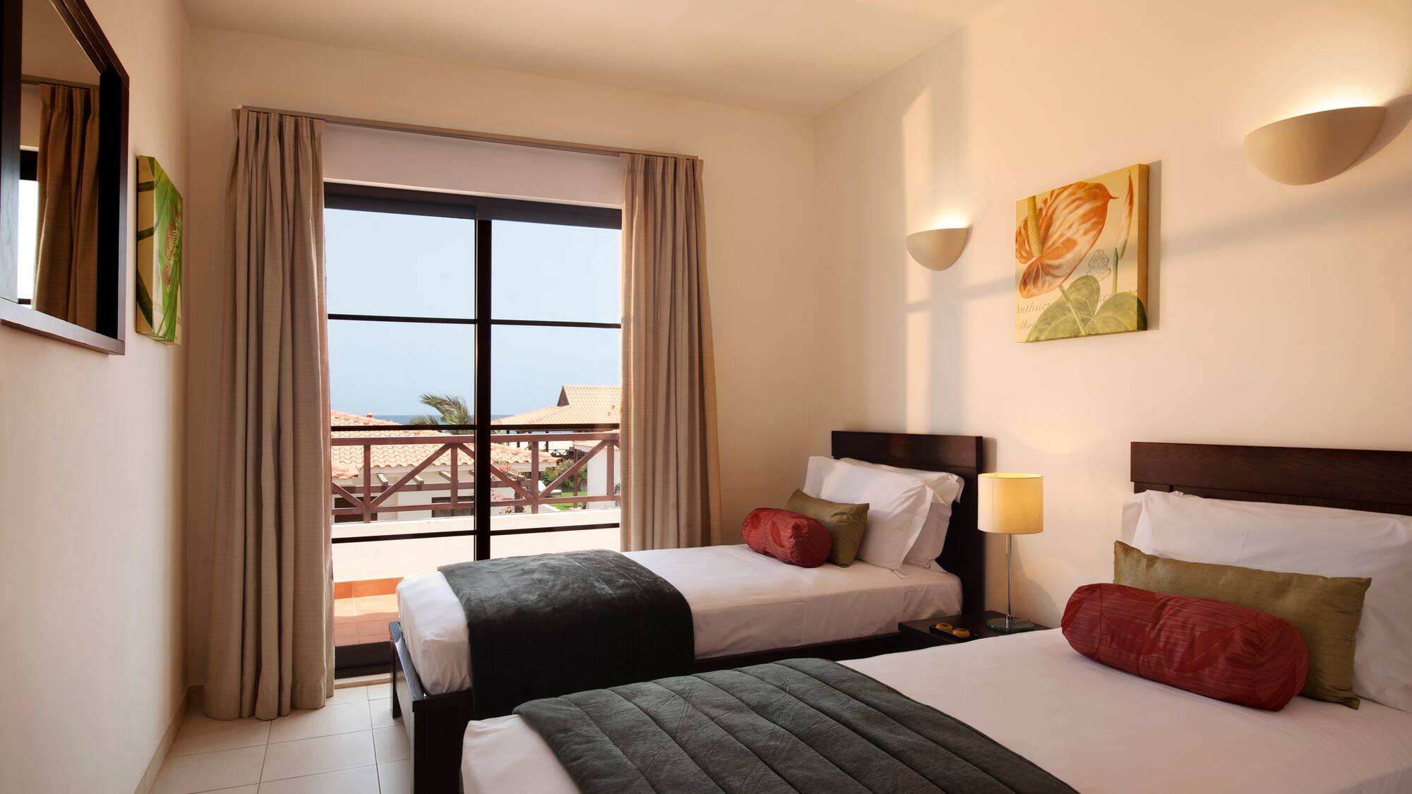 two beds in a room with a balcony