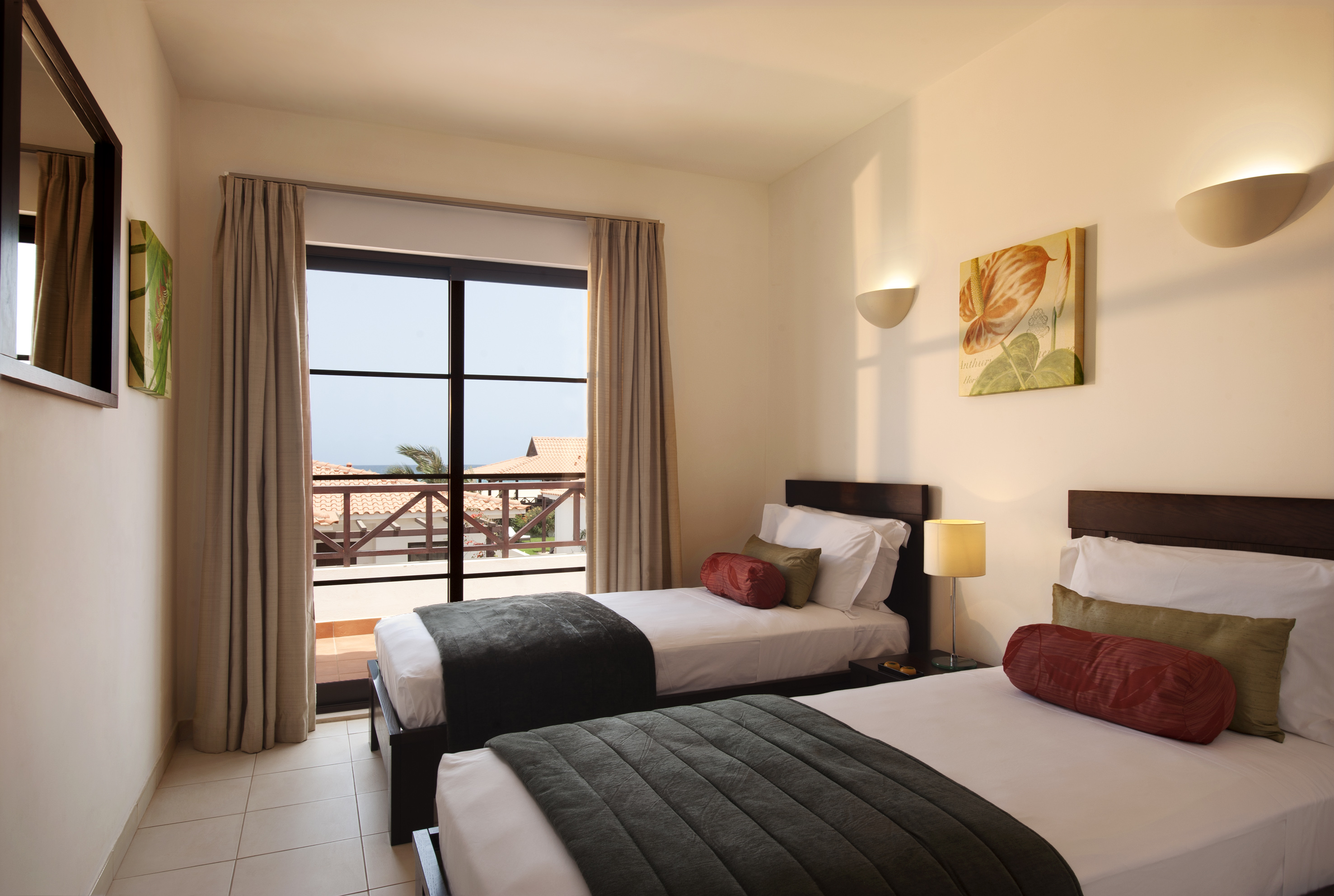 two beds in a room with a balcony