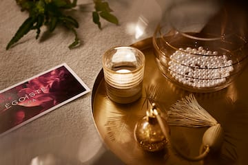 a tray with a candle and pearls on it