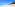 White sand tropical beach, clear turquoise ocean, palm trees, blue sky.