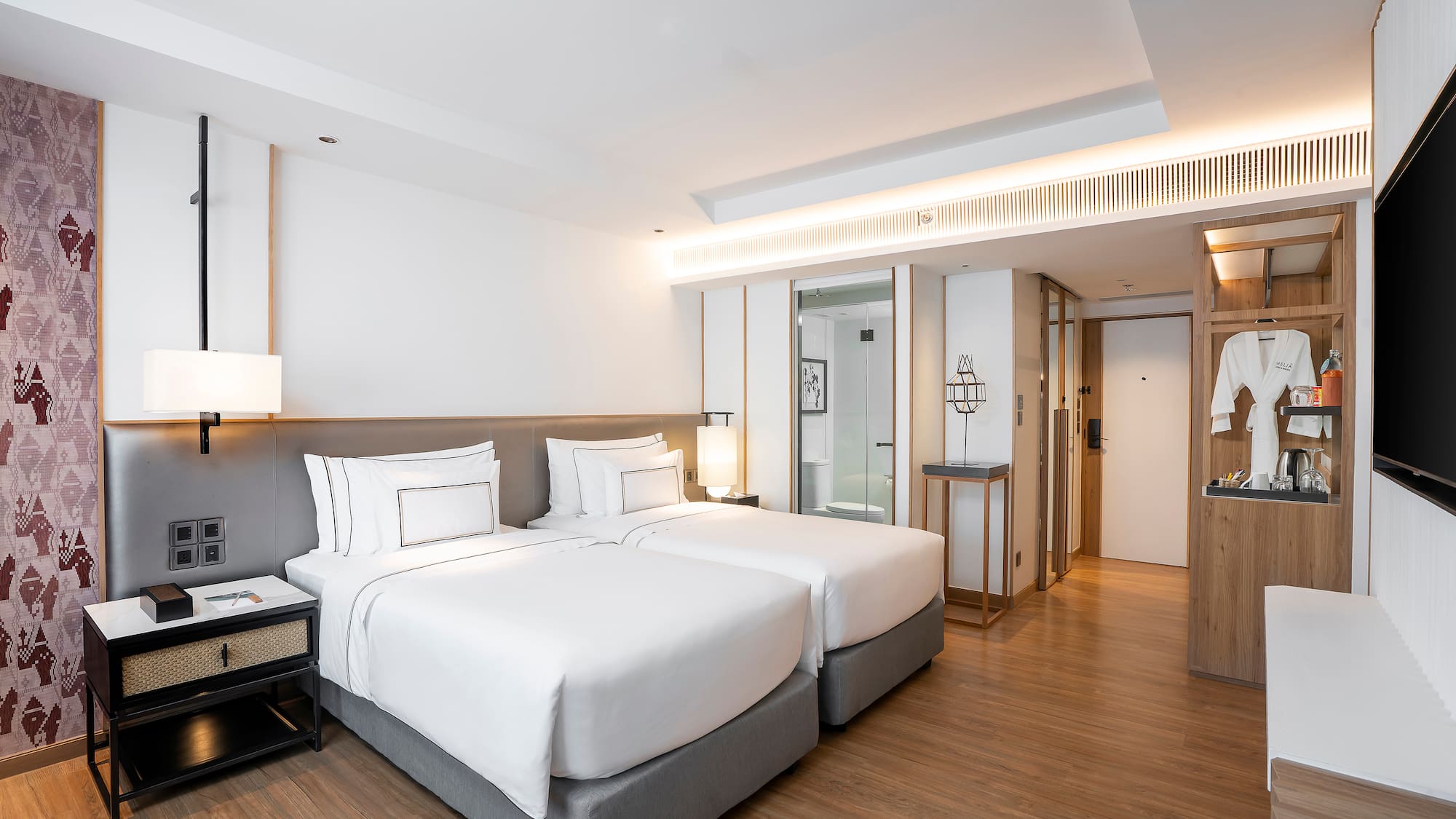 a room with two beds and a wood floor