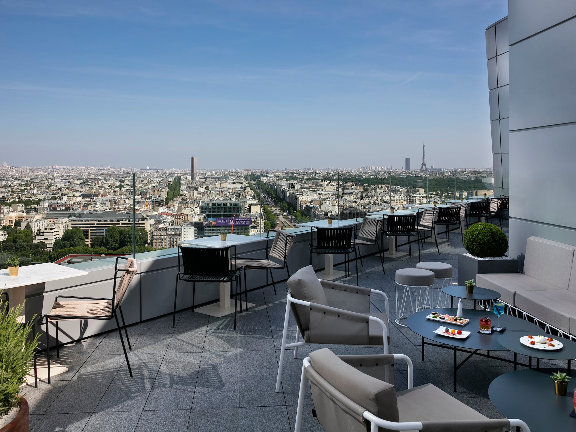 Paris rooftop bar with Eiffel Tower view and modern outdoor lounge seating.