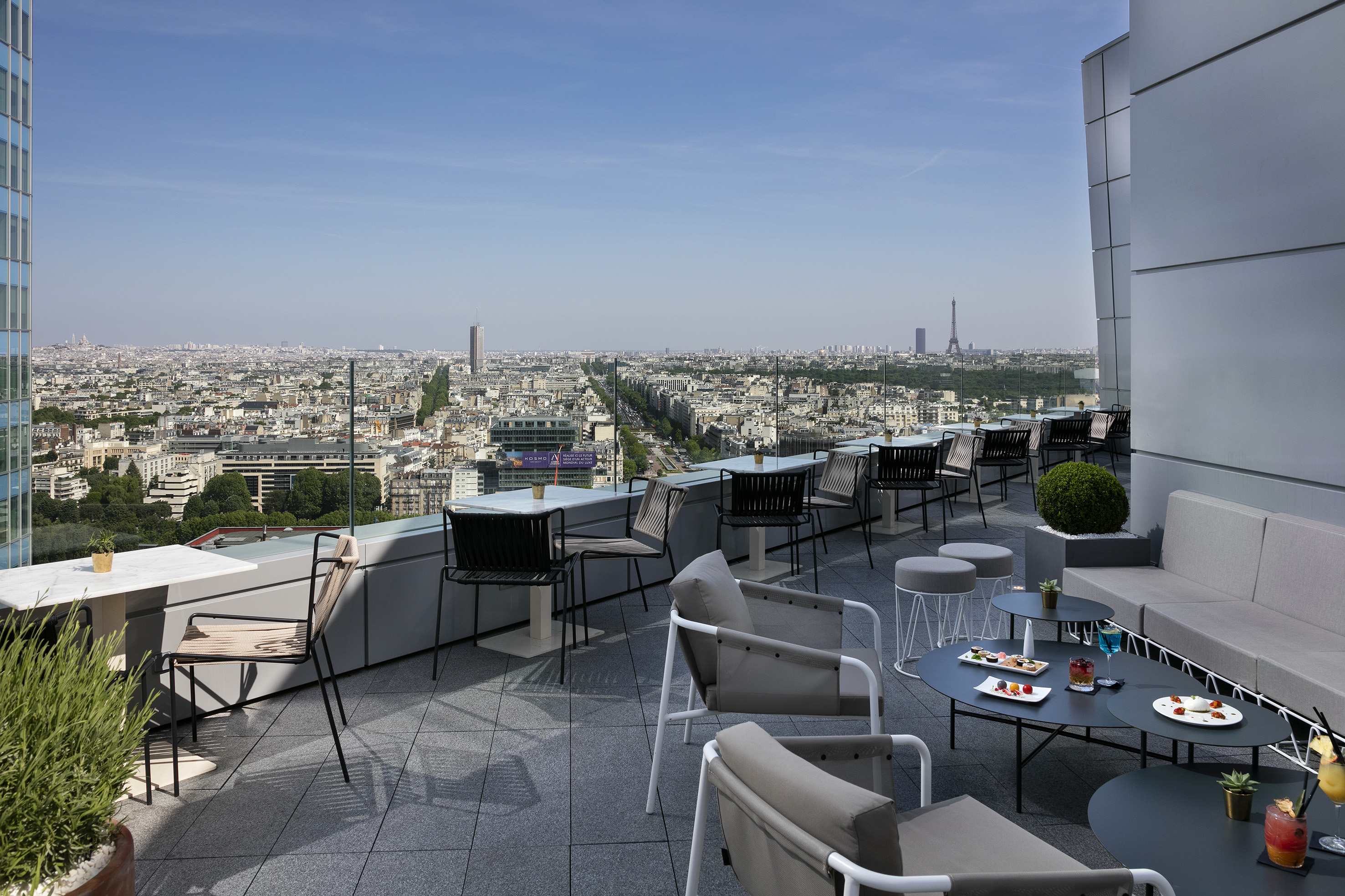 Rooftop terrace in Paris with Eiffel Tower view, city skyline, and outdoor seating.