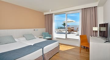 a hotel room with a large window and chairs