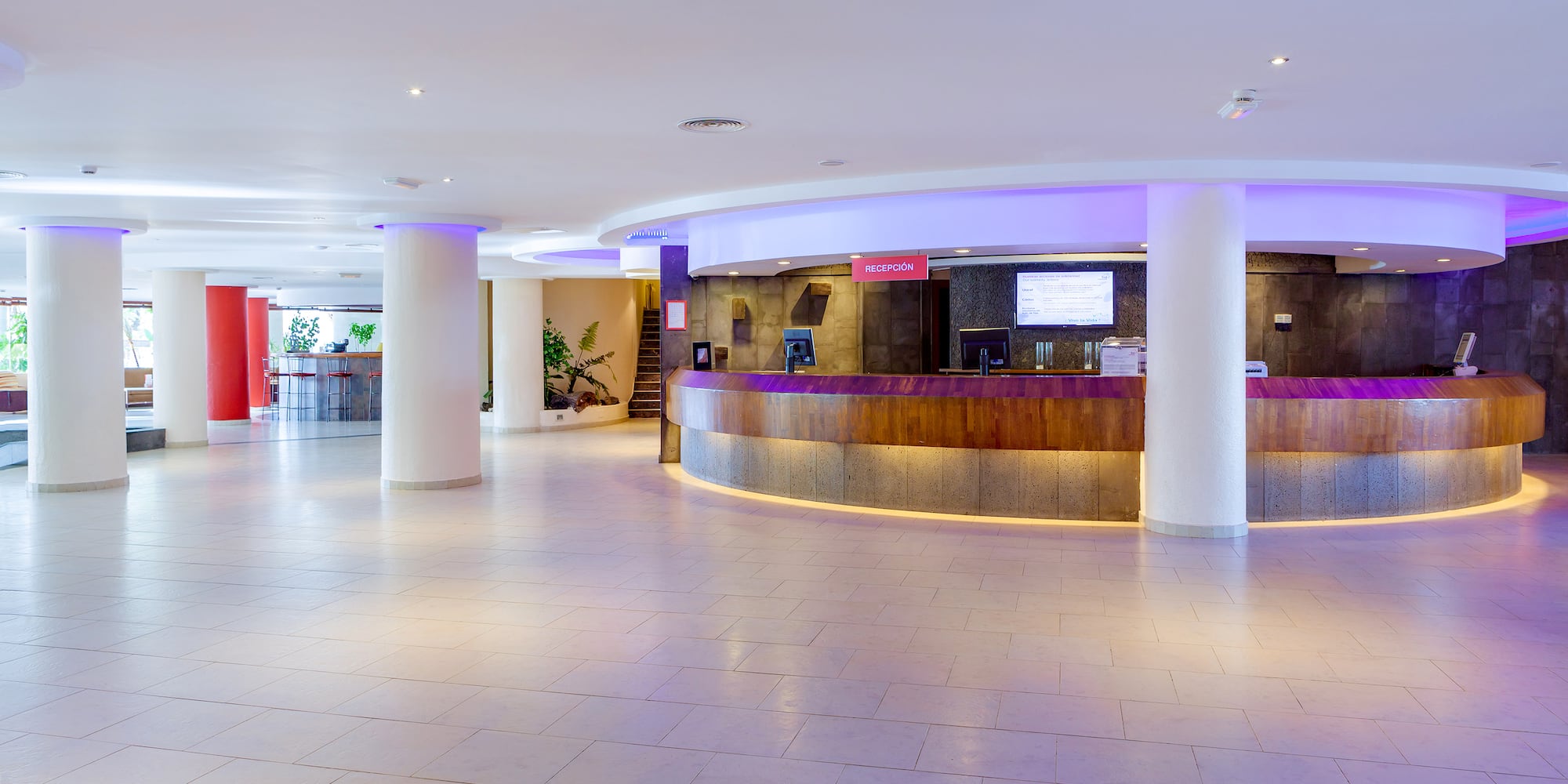 a lobby with a reception desk and a staircase