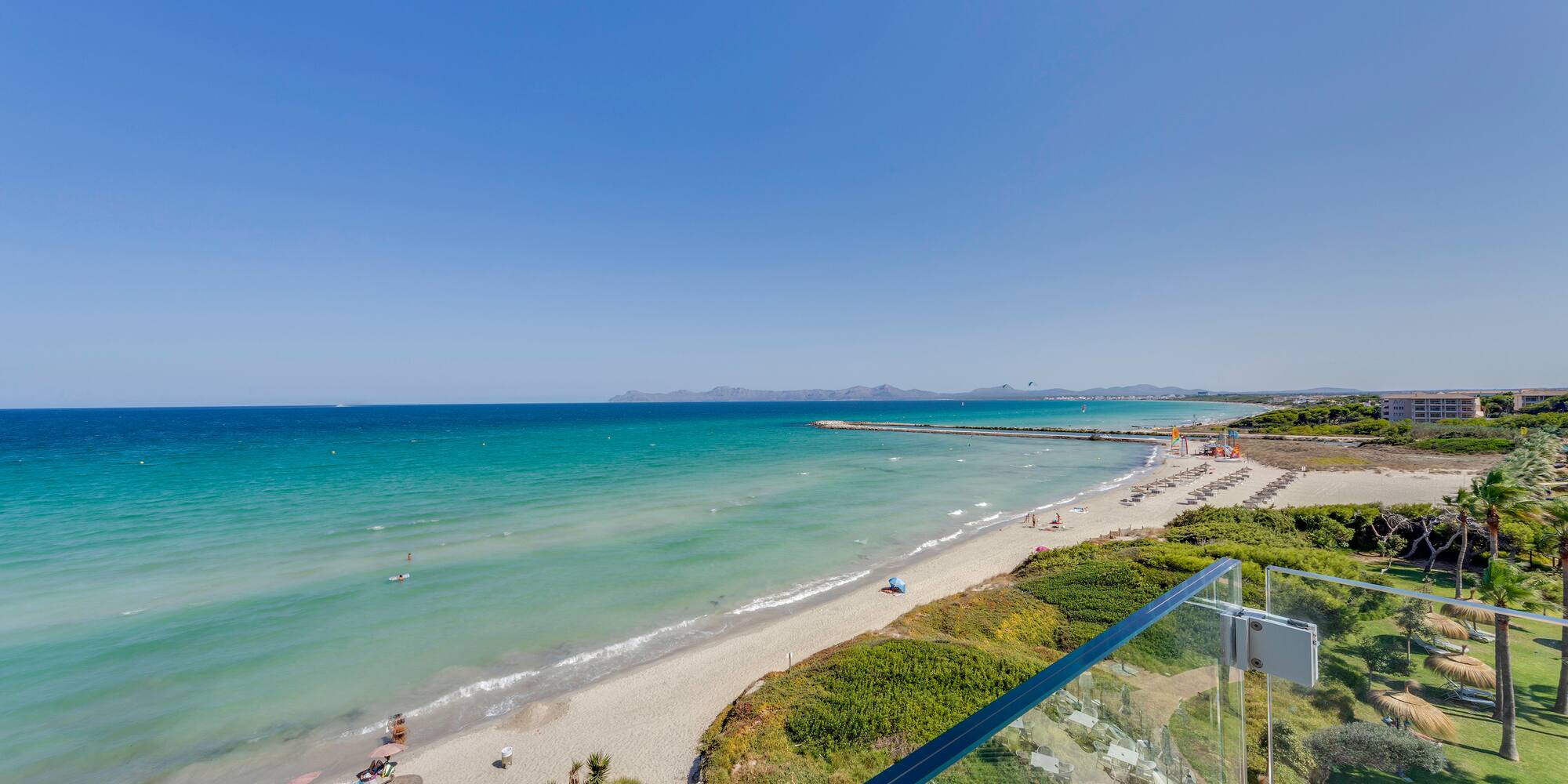 a beach with a clear glass railing
