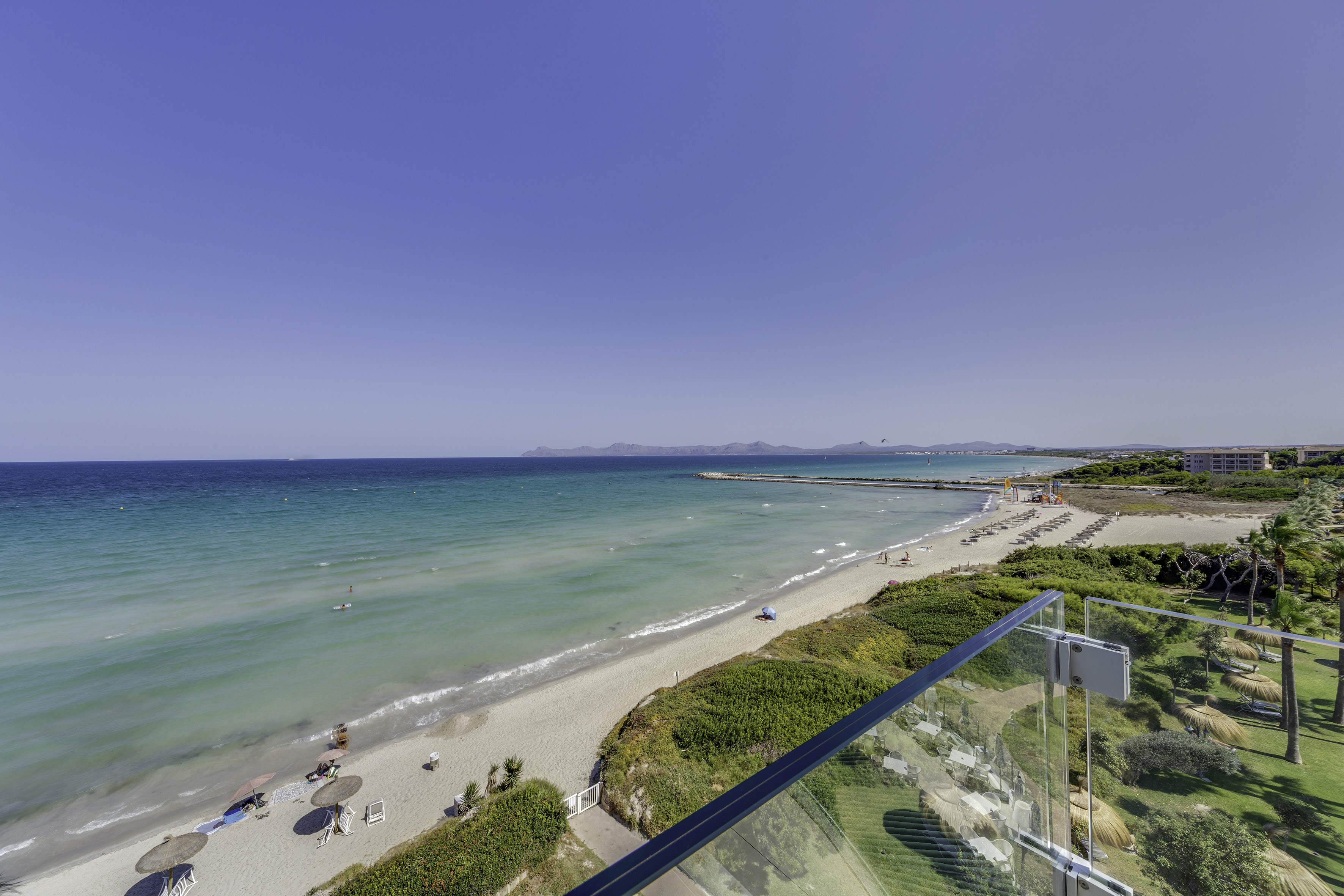 a beach with a clear glass railing