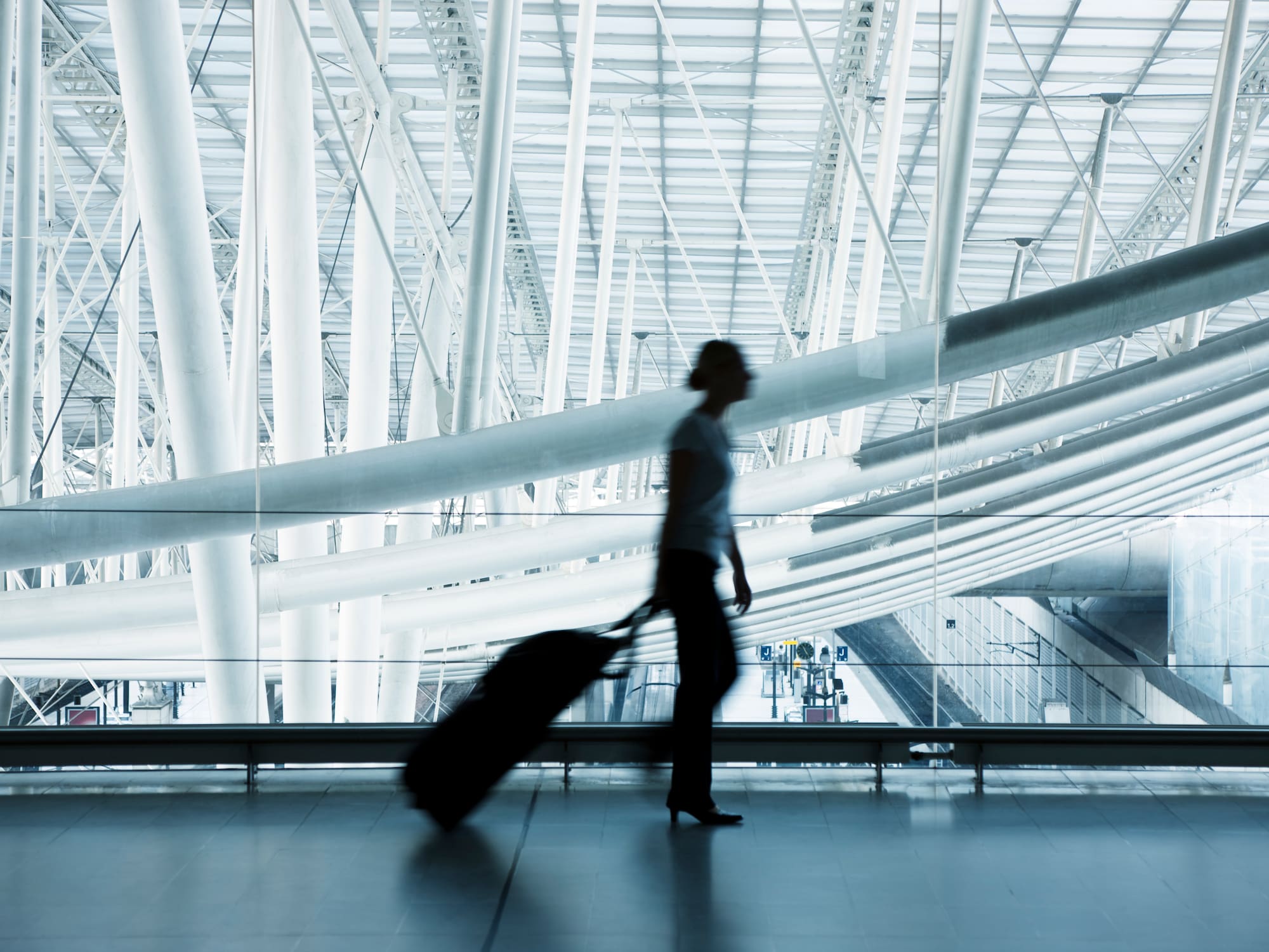 a woman walking with luggage in a airport