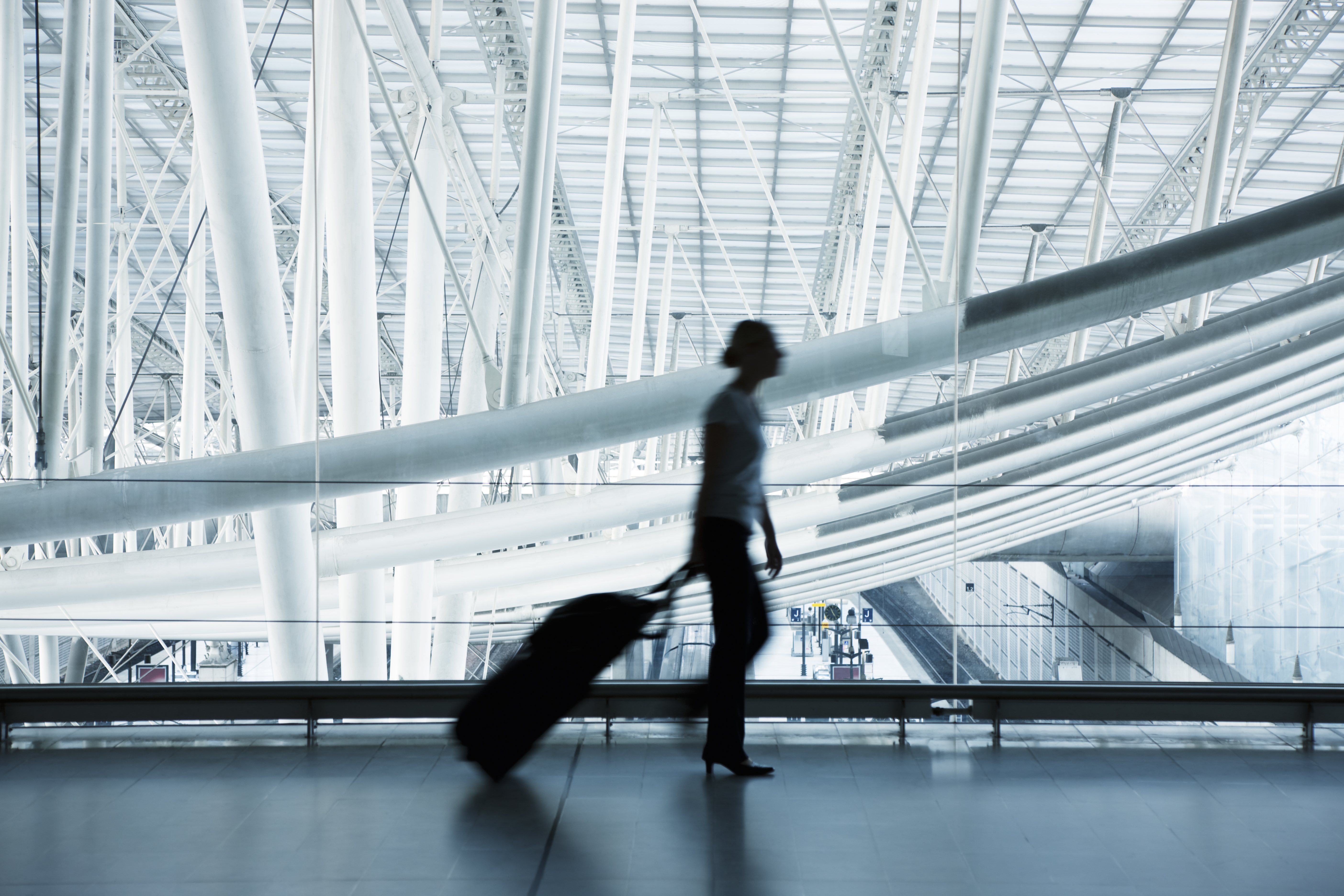 a woman walking with luggage in a airport