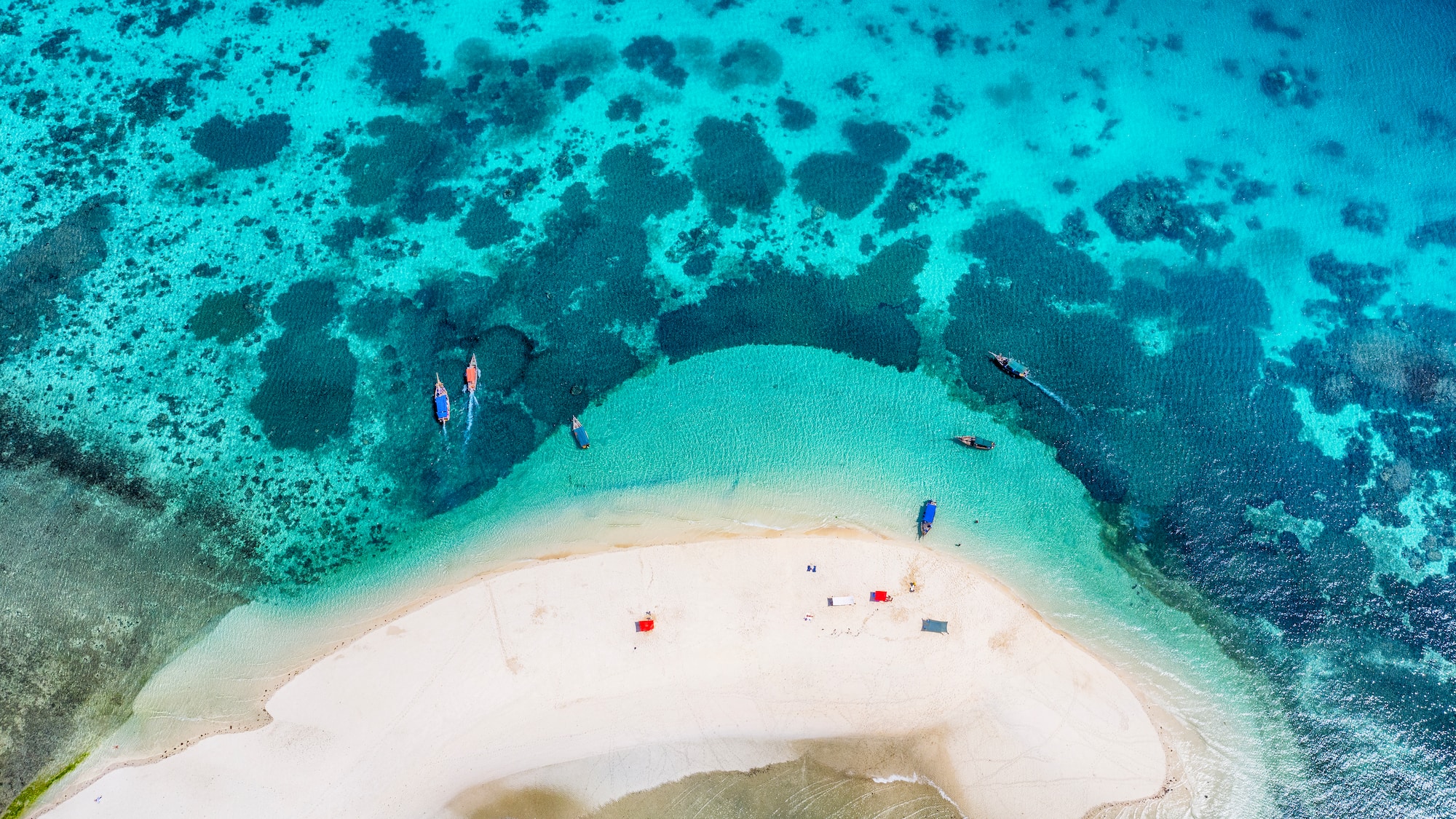 a beach with boats and a sandy island