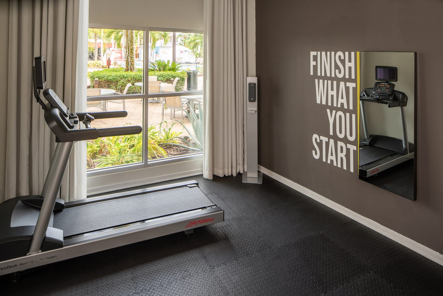 a gym with treadmills and a window