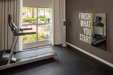 a gym with treadmills and a window