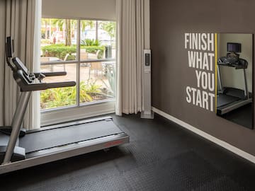 a gym with treadmills and a window