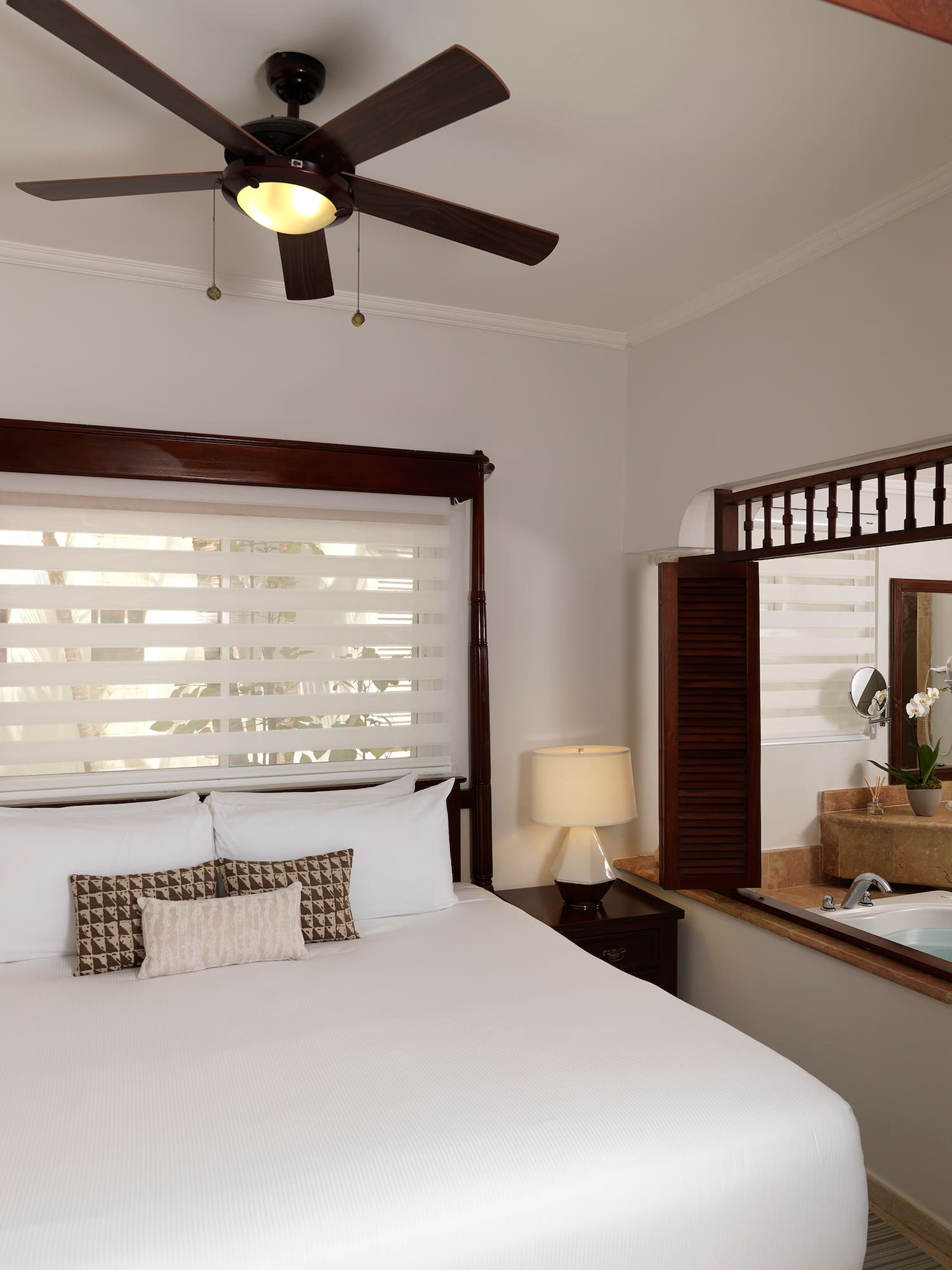 a bed with a fan and a window