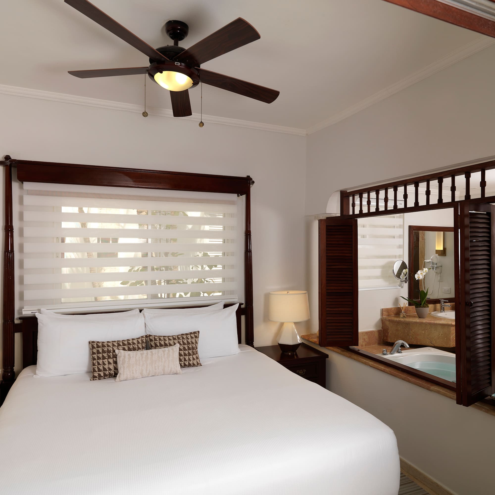 a bed with a fan and a window