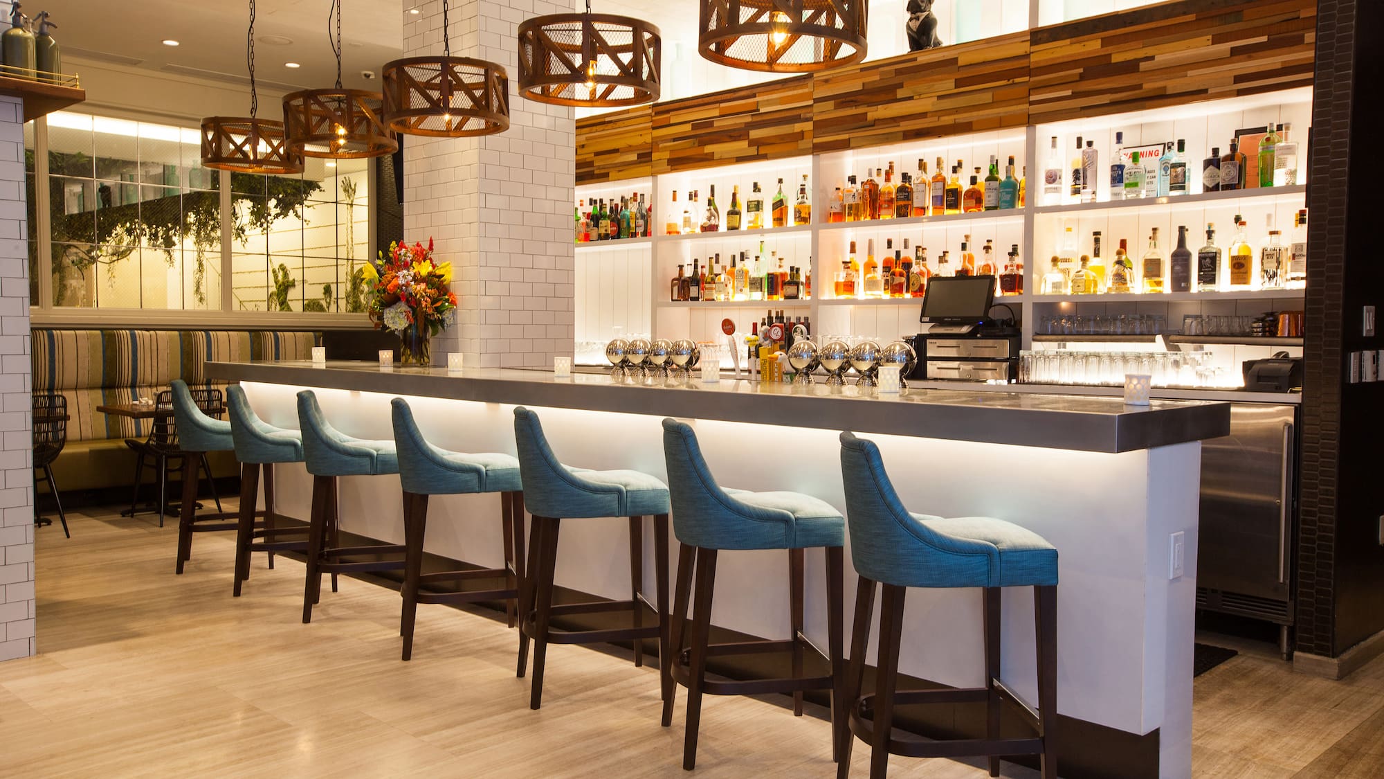a bar with a row of stools and bottles