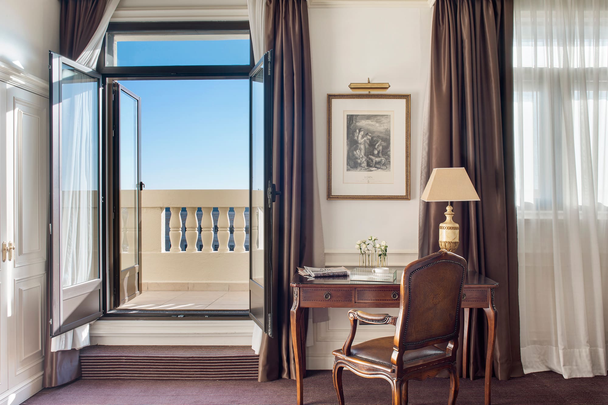 a desk and chair in a room with curtains and a window
