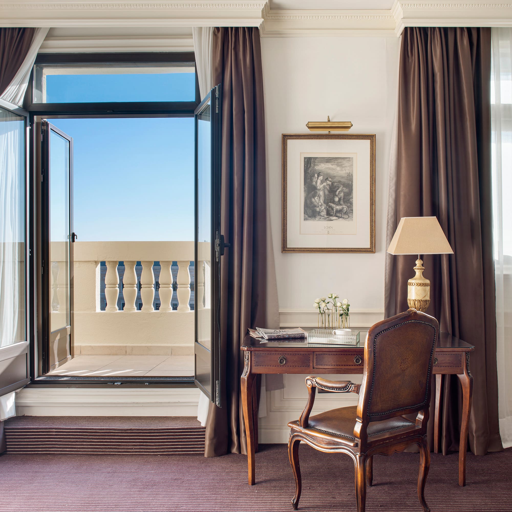 a desk and chair in a room with curtains and a window
