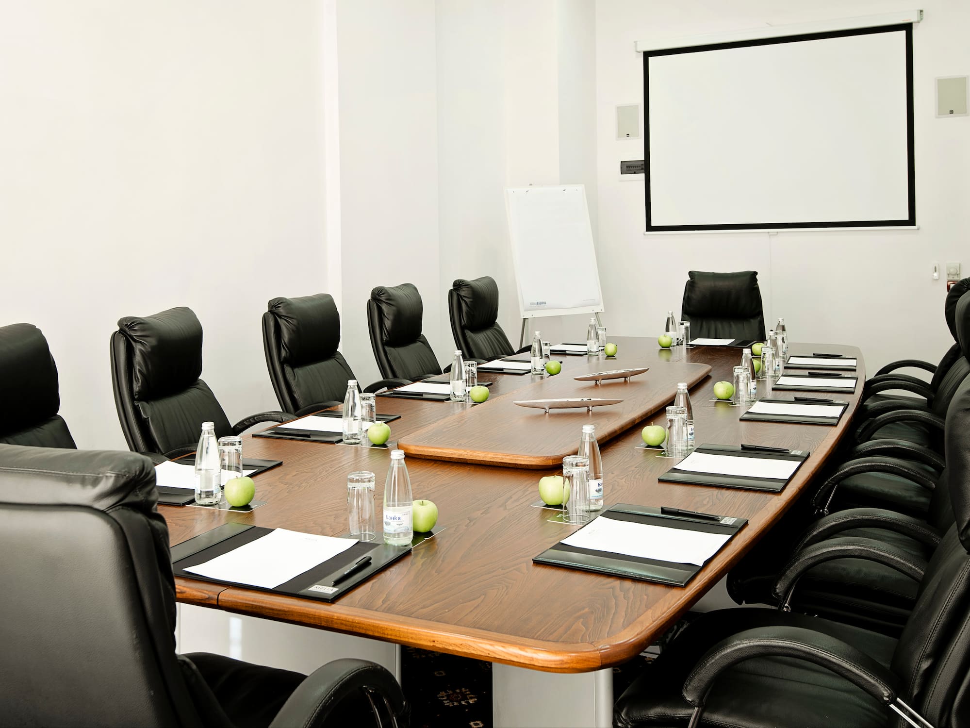a conference room with chairs and a table with a white board