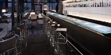 a bar with a row of chairs and a counter
