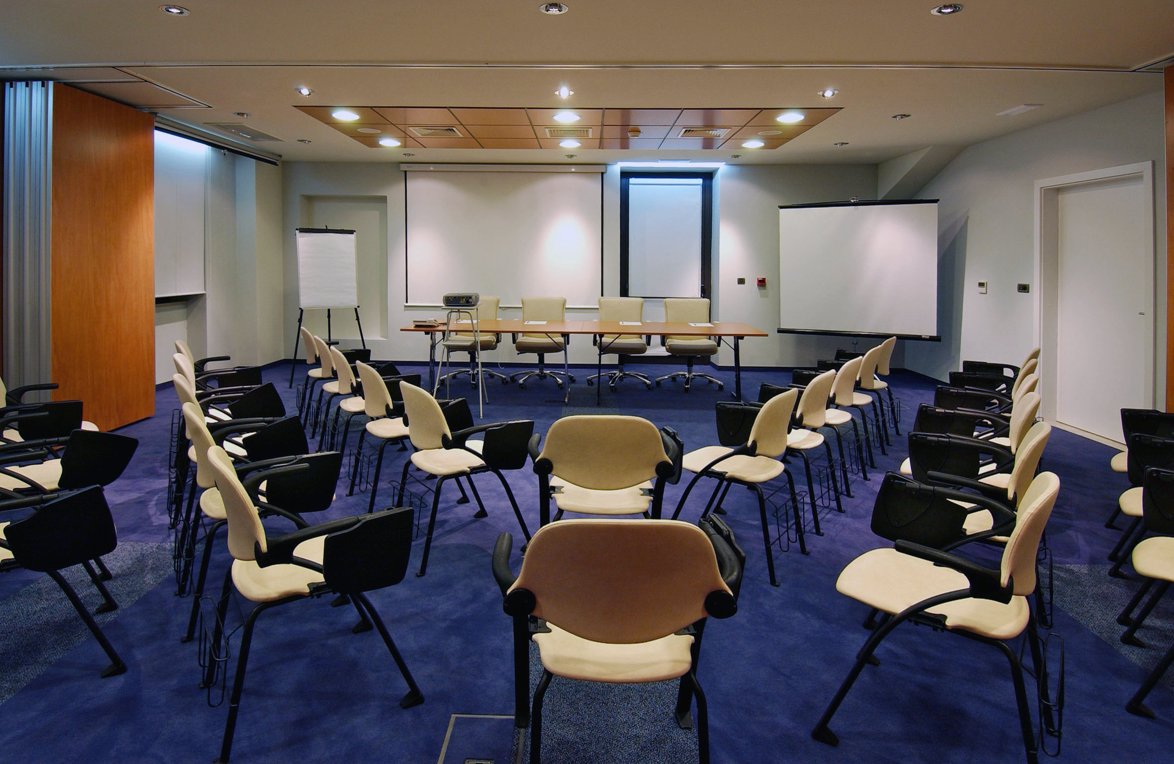 a room with chairs and a projector screen
