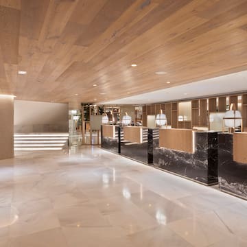 a lobby with marble flooring and a wood ceiling