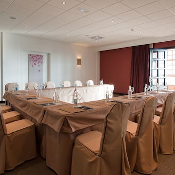 a room with a long table with chairs and glasses