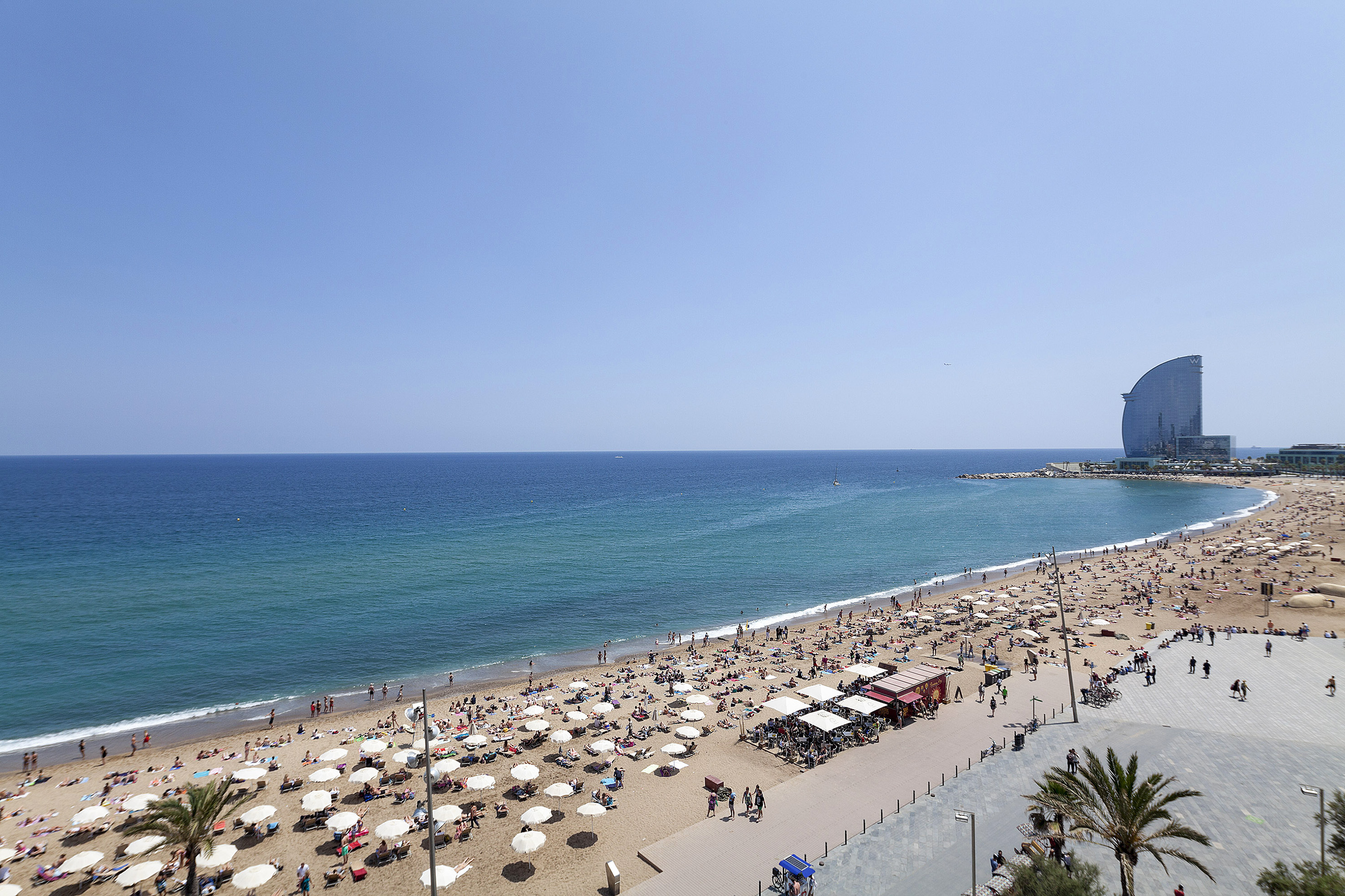 Aerial view of Barcelona beach with W Hotel, many sunbathers, and blue sea. - كل شيء في متناول يدك - فندق برشلونة كوندال مار(Condal Mar) المنتسب لـ Melia, برشلونة