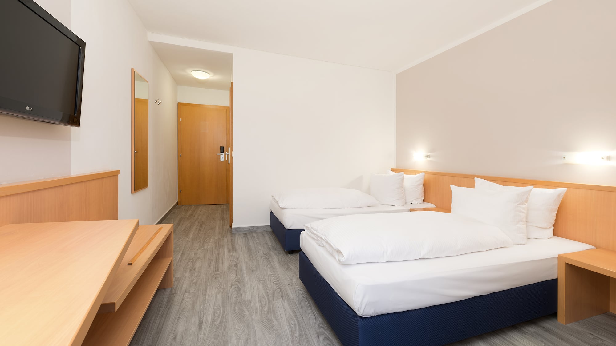 a room with two beds and a wood floor