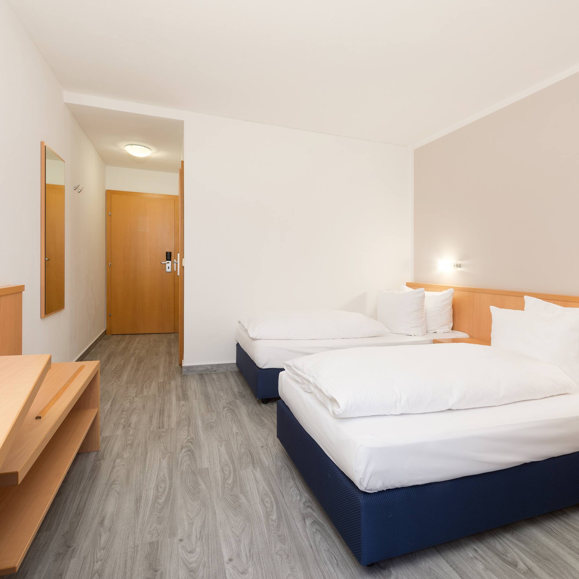 a room with two beds and a wood floor