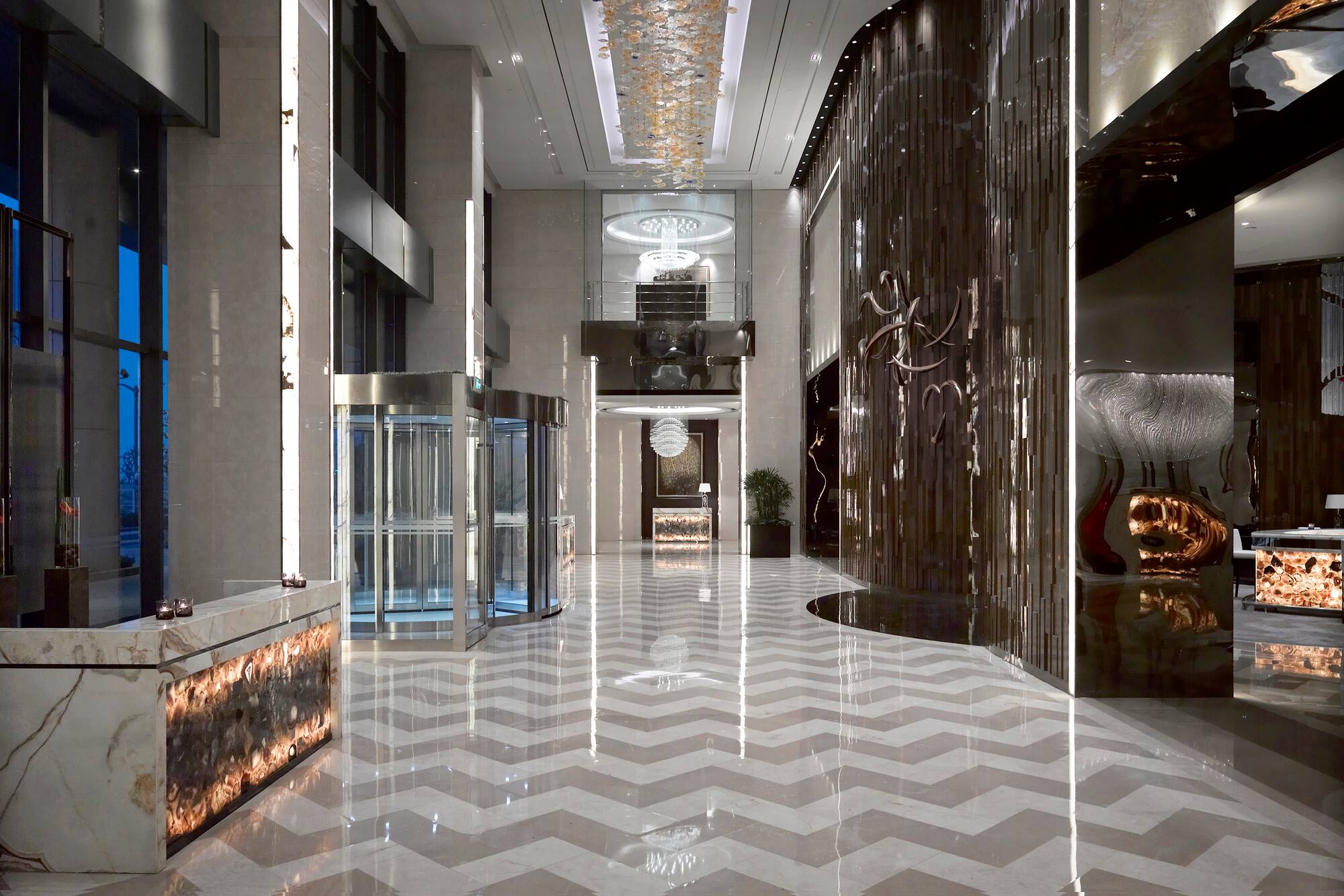 Luxury hotel lobby, chevron marble floor, crystal chandeliers, modern reception.