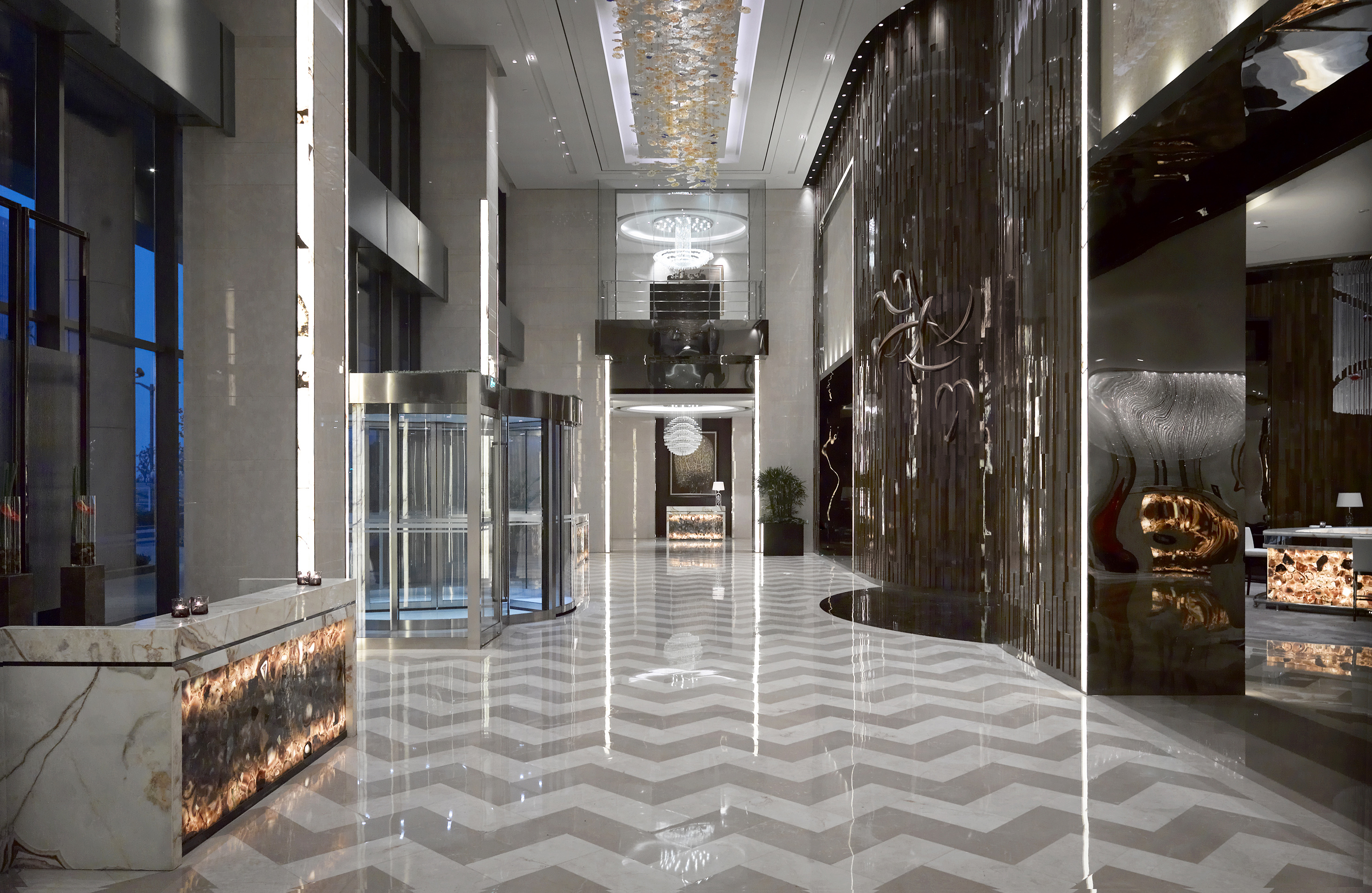 Luxury hotel lobby, chevron marble floor, crystal chandeliers, modern reception.