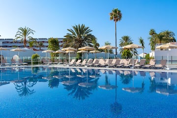 a pool with lounge chairs and umbrellas