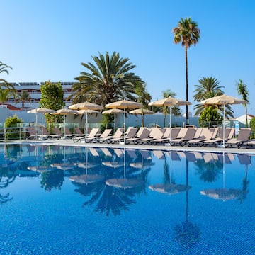 a pool with lounge chairs and umbrellas