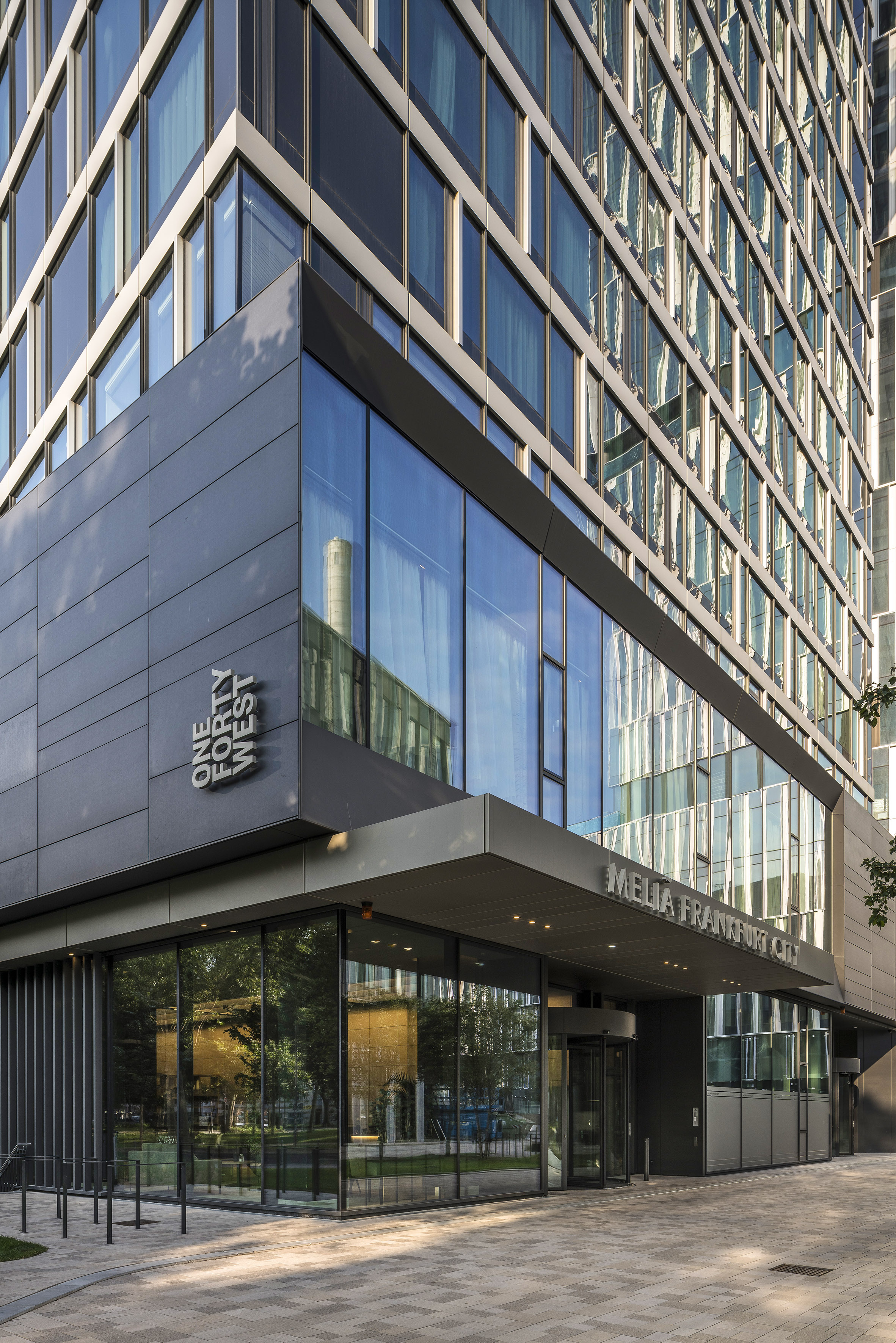 Modern Meliá Frankfurt City hotel with glass facade and 'ONE FORTY WEST' sign.