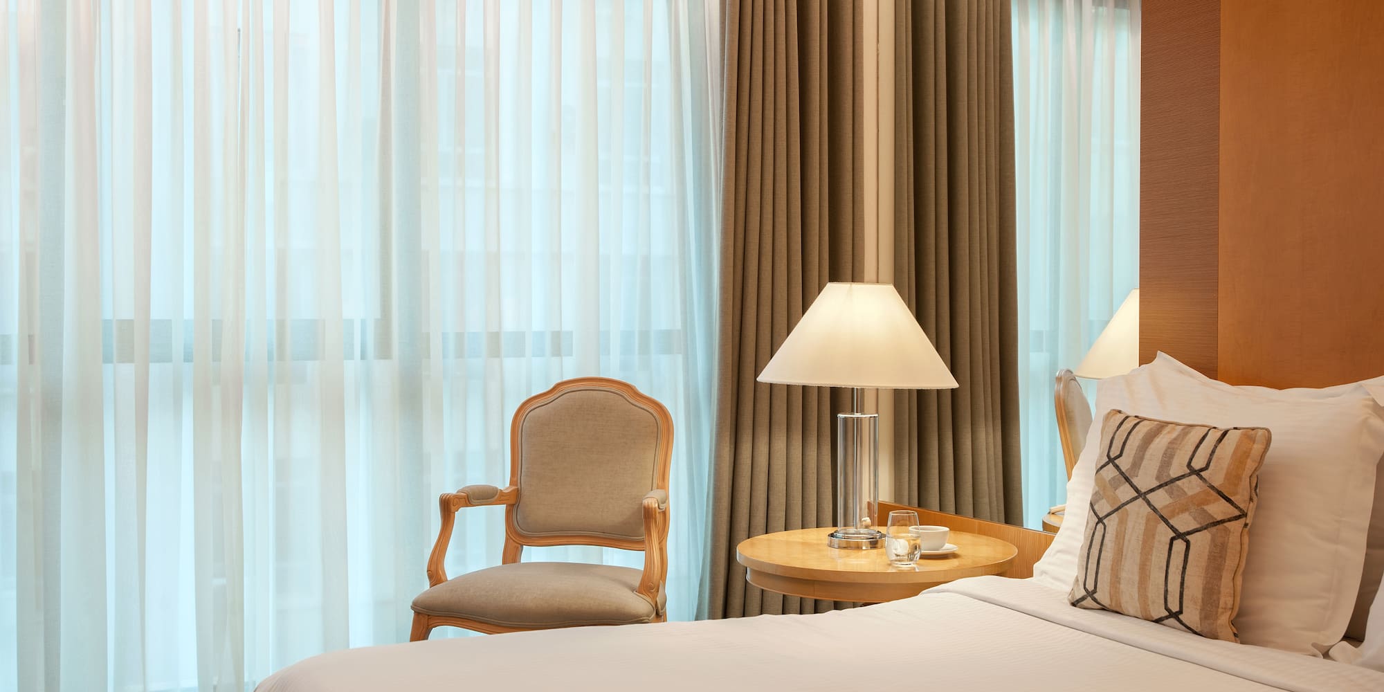 a bed with a lamp and a chair in a room