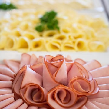 a plate of food with a flower shaped arrangement of meat