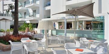 a patio with tables and chairs and umbrellas